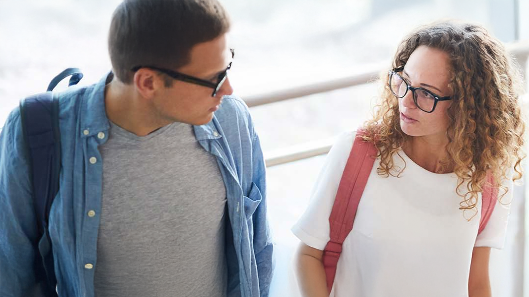 Ein Schüler und einen Schülerin sprechen zusammen