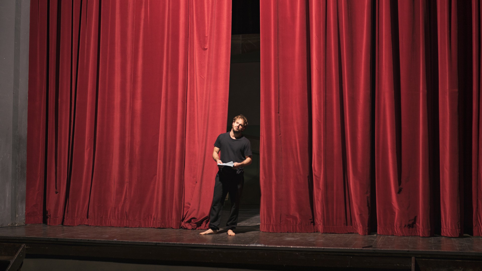 Des acteurs aux pieds nus sur la scène du théâtre avec un scénario