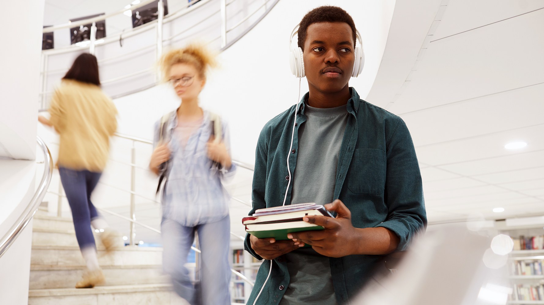 Un étudiant descend un escalier dans la bibliothèque